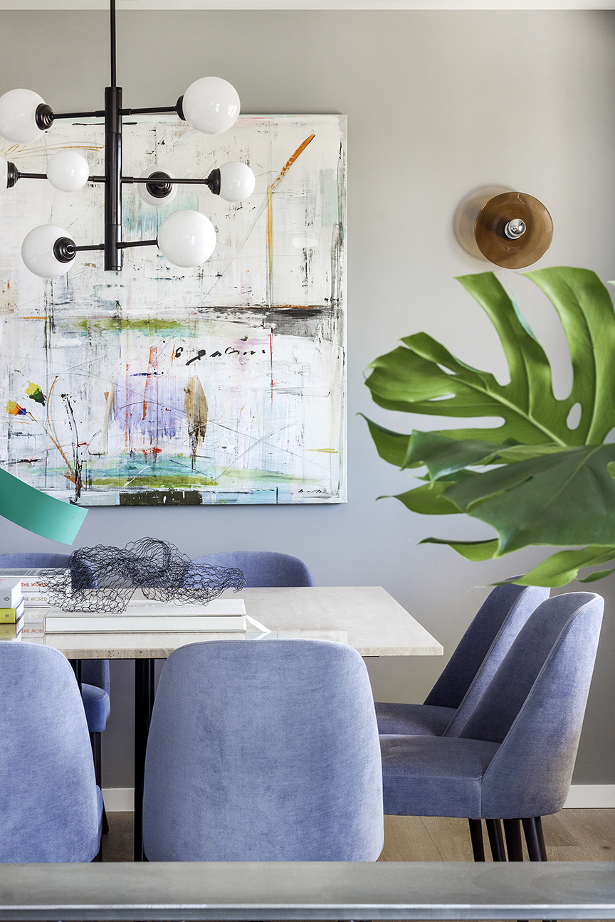 Reforma integral y decoración vivienda. Detalle de comedor, Mesa con tapa de travertino, sillas tapizadas en azul y lámpara tubular negra con globos opal.